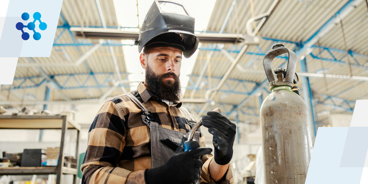 a man wearing a welding helmet is working on a piece of metal