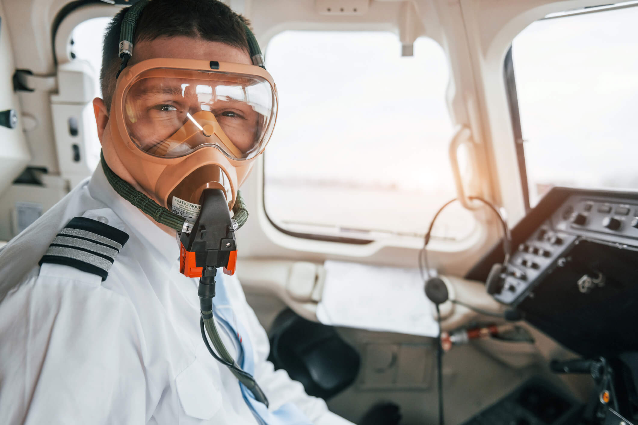 a pilot wearing a gas mask and goggles looks at the camera