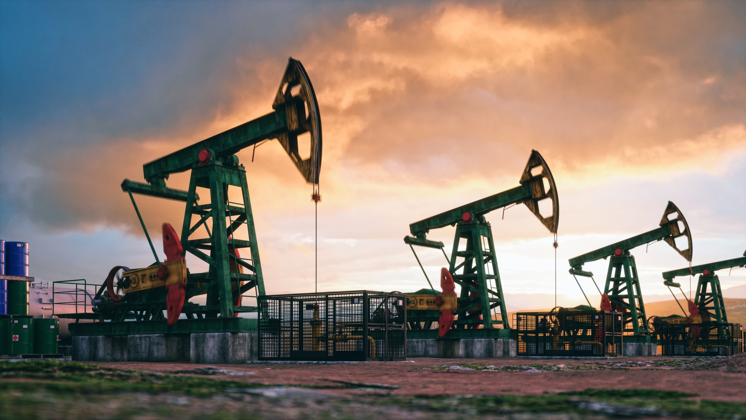 a row of oil pumps with a sunset in the background