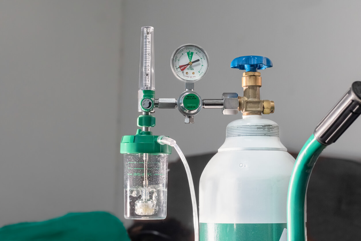 an oxygen cylinder with a gauge attached to it