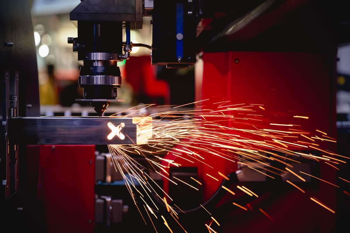 a machine is cutting a piece of metal with an x on it